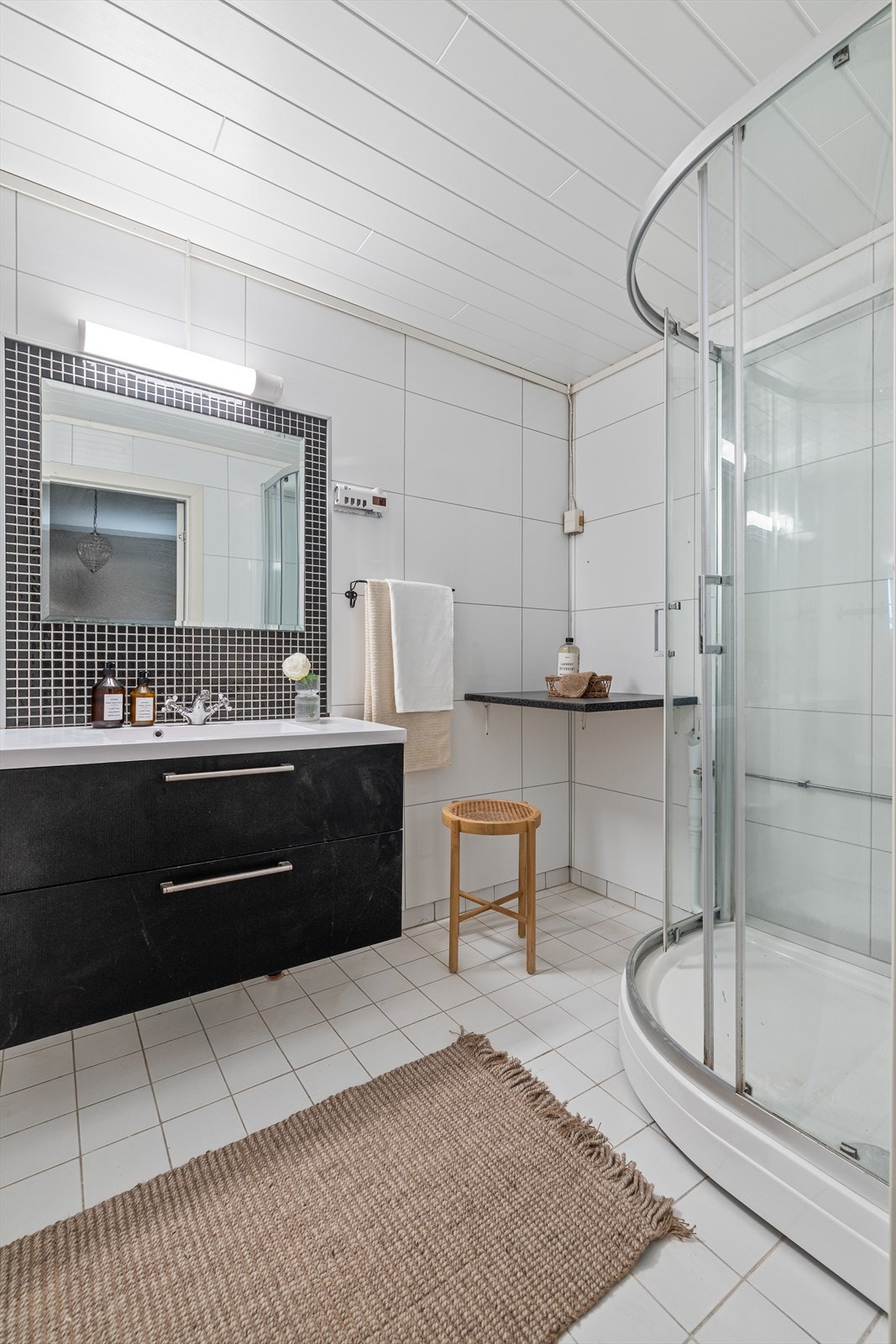 Badet er innredet med gulvstående toalett, dusjkabinett og opplegg for vaskemaskin. Badet har innredning med nedfelt servant Galleribilde