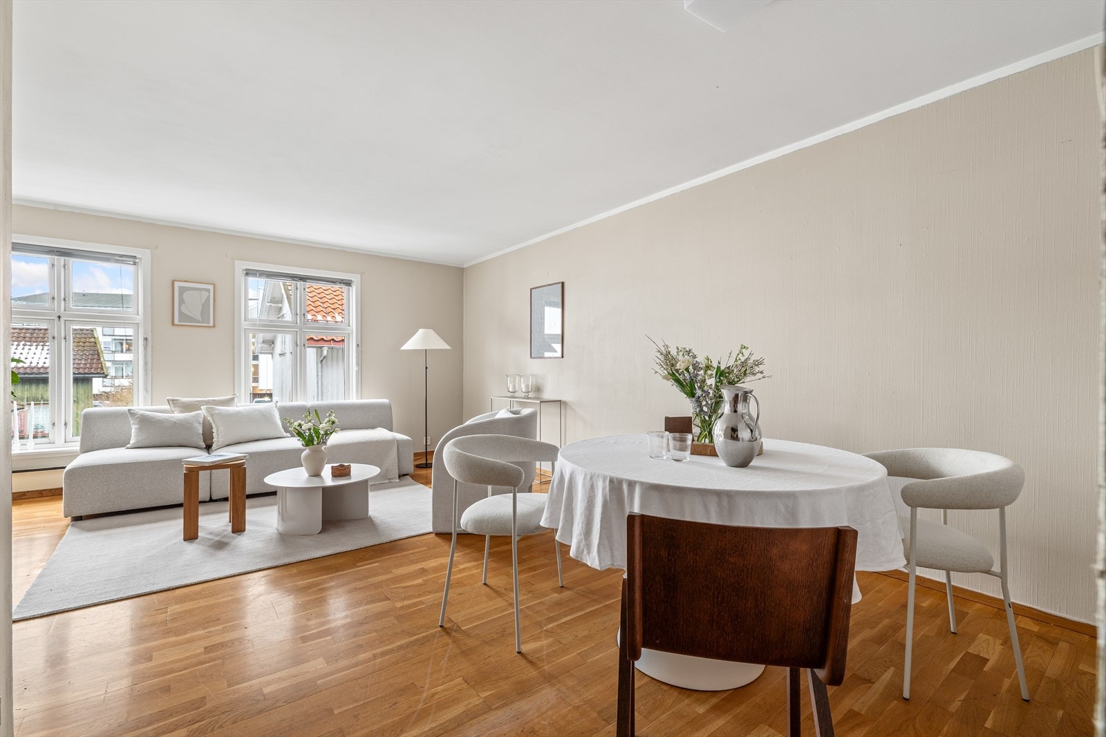 Romslig stue som er hjerte av leiligheten. Det er parkett på gulv og malte plater på vegger. Galleribilde