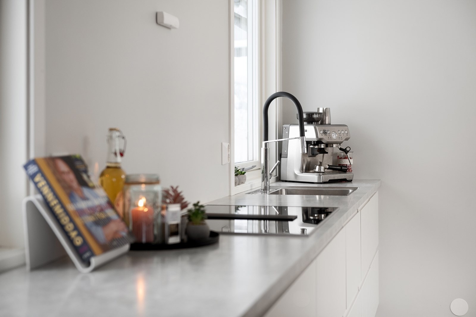 Kjøkkenet er utstyrt med integrerte hvitevarer og underlimt vask for et sømløst uttrykk. Galleribilde