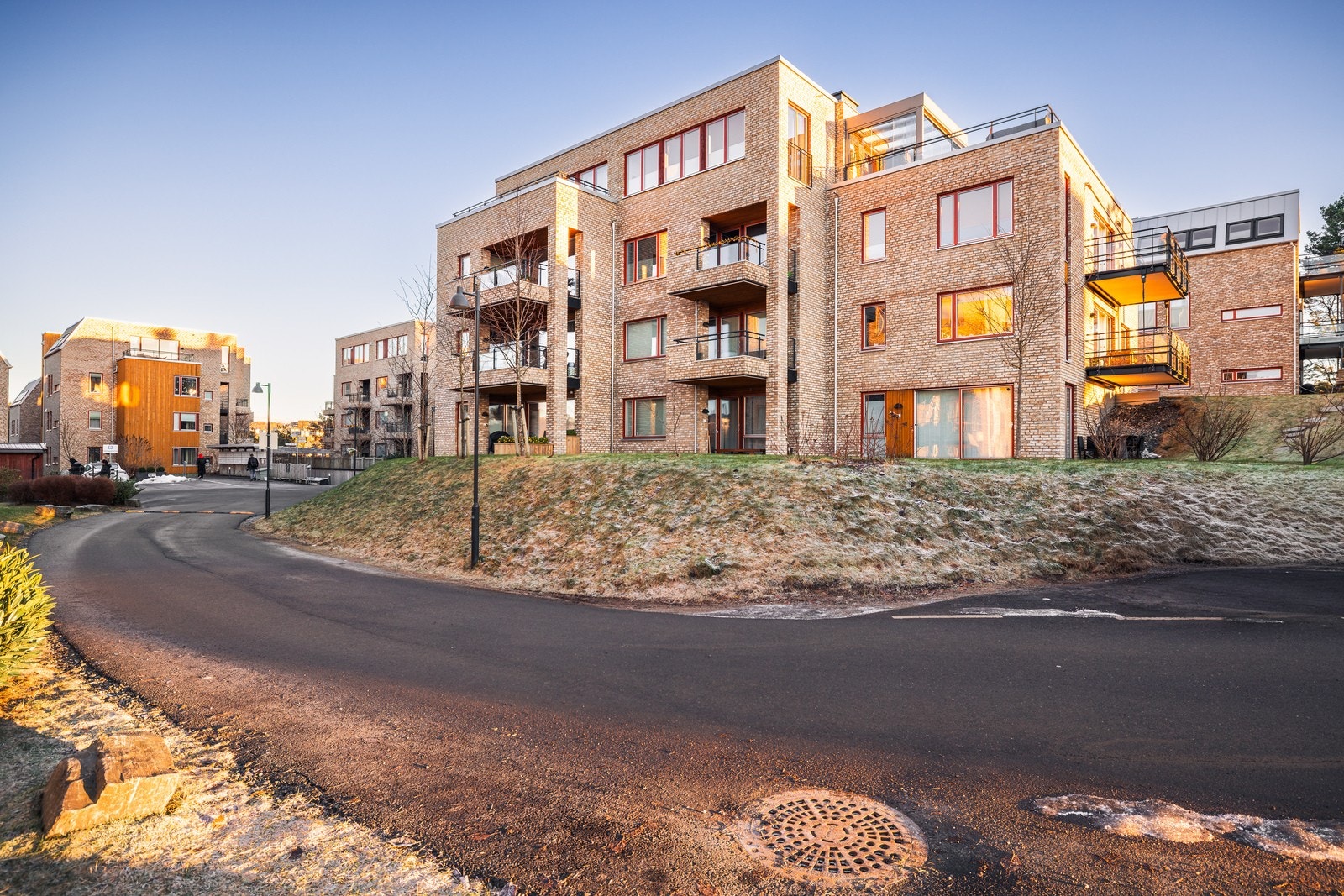 Fellesarealet er opparbeidet med asfaltert innkjørsel og p-plasser, interne stier, bed/beplantninger, plen, lekeområde, naturområder og trær. Galleribilde