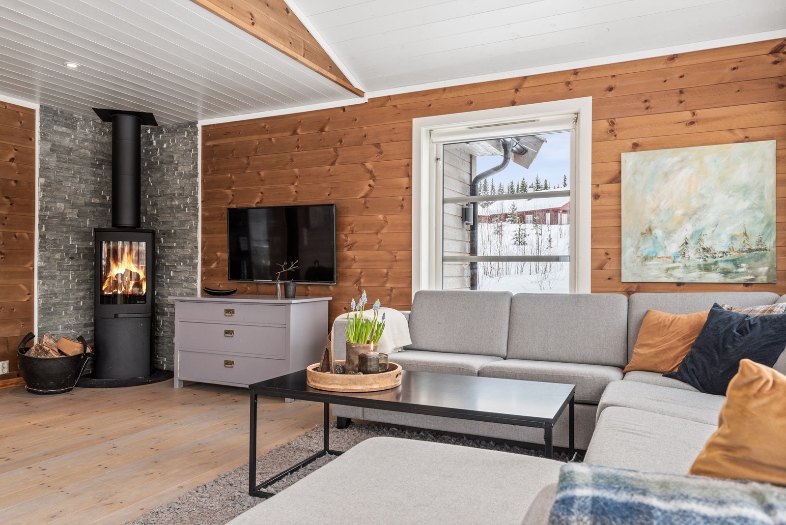 Peisen er rentbrennende og varmer godt på kalde dager. Skiferbelagt vegg ved peisen gir et rustikk og røft preg. Galleribilde