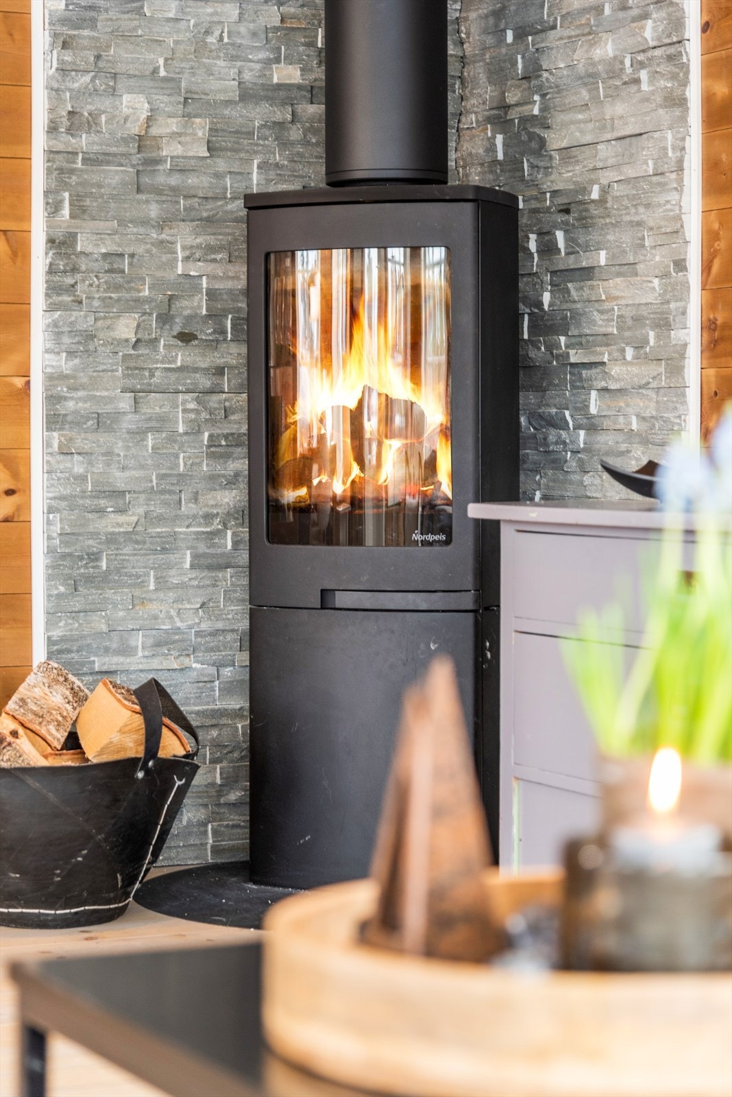 Peisen er rentbrennende og varmer godt på kalde dager. Skiferbelagt vegg ved peisen gir et rustikk og røft preg. Galleribilde