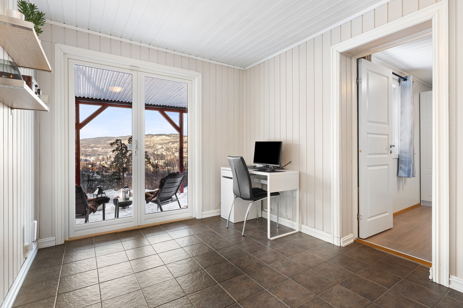 Fra stuen er det utgang til en romslig terrasse og boligens hage. Galleribilde