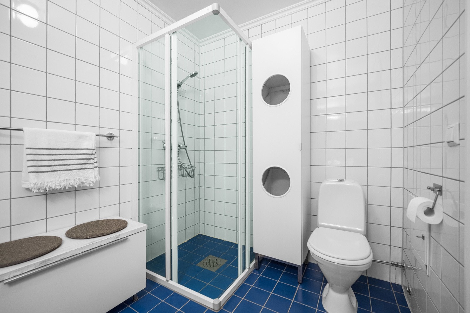 Badet er innredet med wc, dusjhjørne, servant med innredning og opplegg til vaskemaskin. Galleribilde