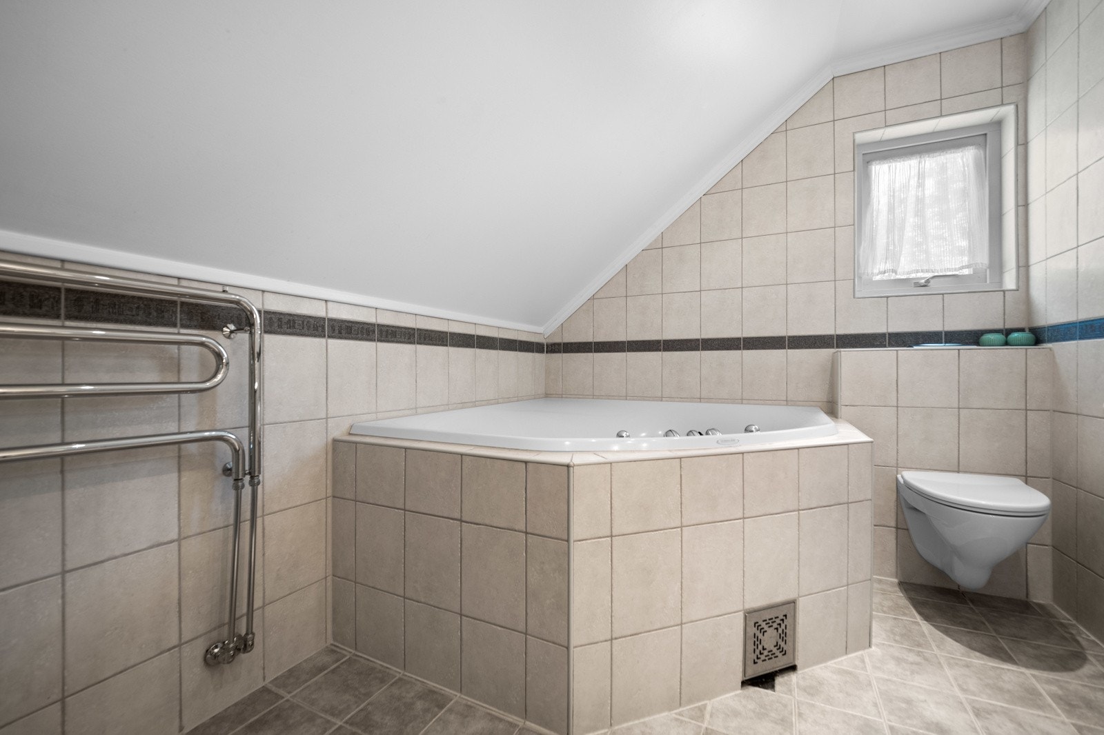 Badet inneholder badekar, wc, dusjhjørne og servant med innredning. Galleribilde