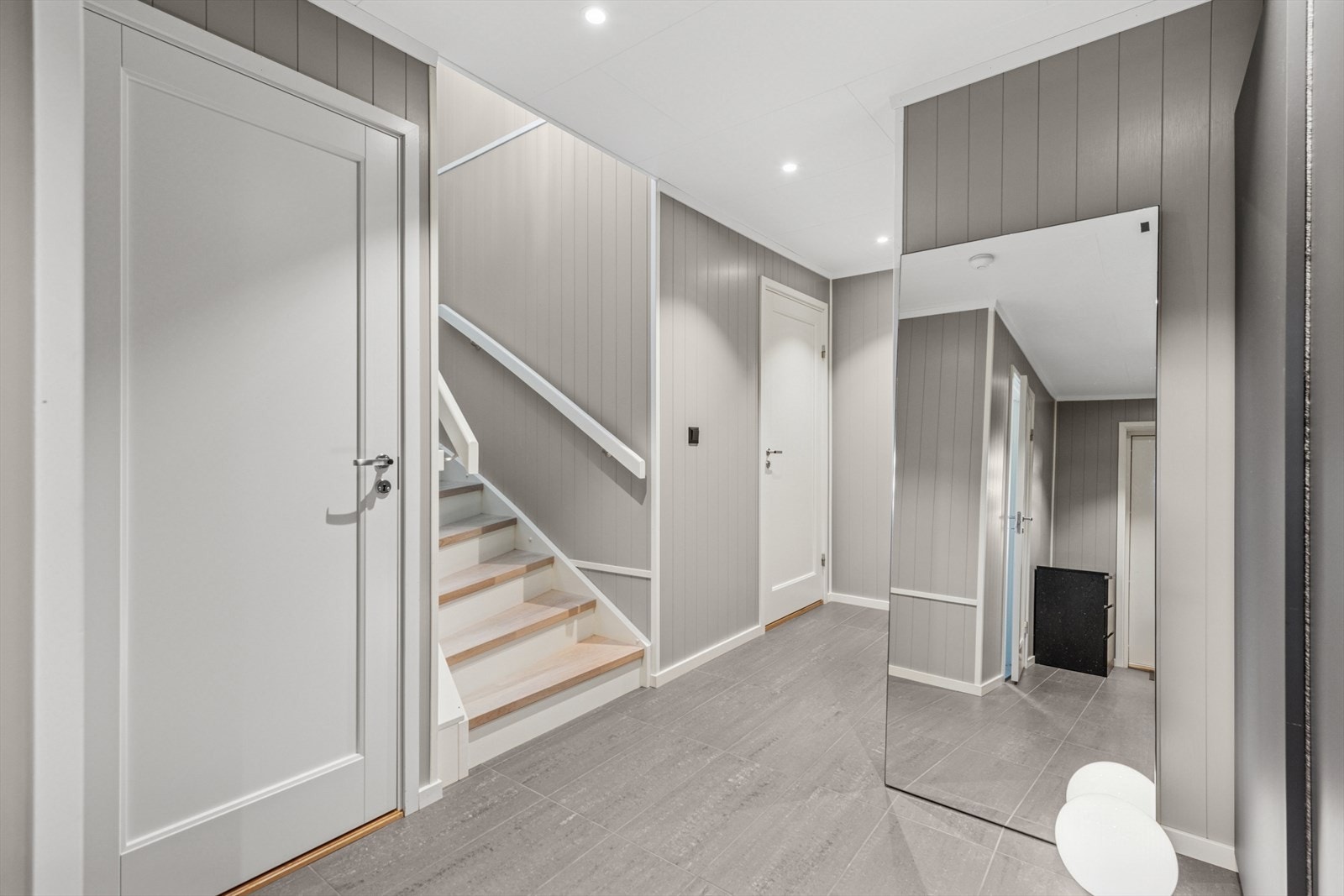 Romslig entré med god plass til oppbevaring og trappeadkomst til boligens hovedetasje. Galleribilde