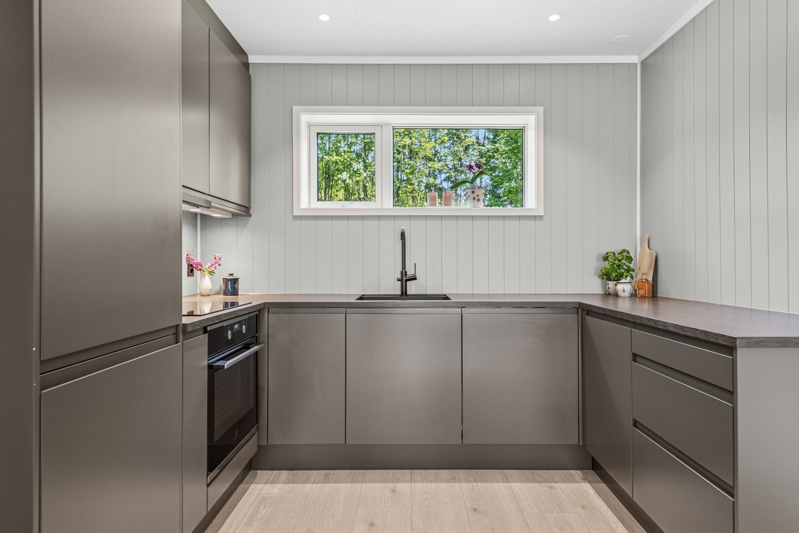 Kjøkkenet har en stilren innredning med laminerte skrog og glatte fronter. Galleribilde