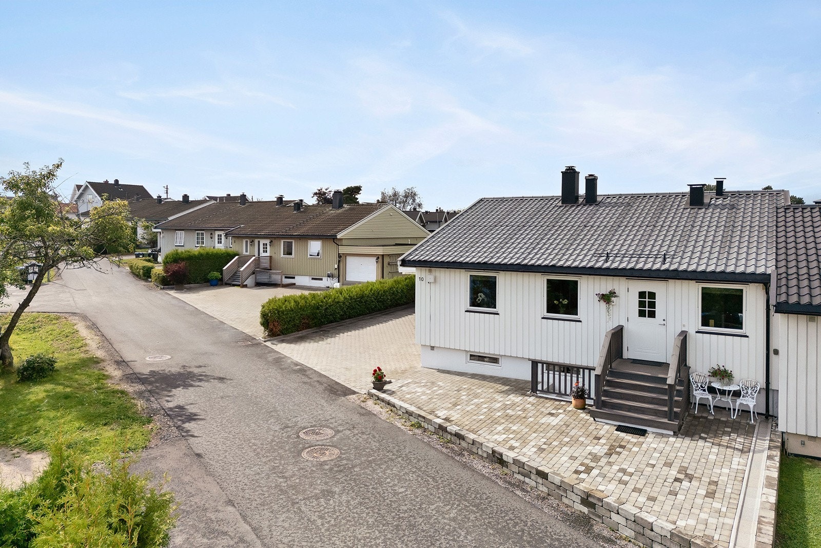 Pen, opparbeidet steinbelagt gårdsplass med plass til parkering av flere biler Galleribilde