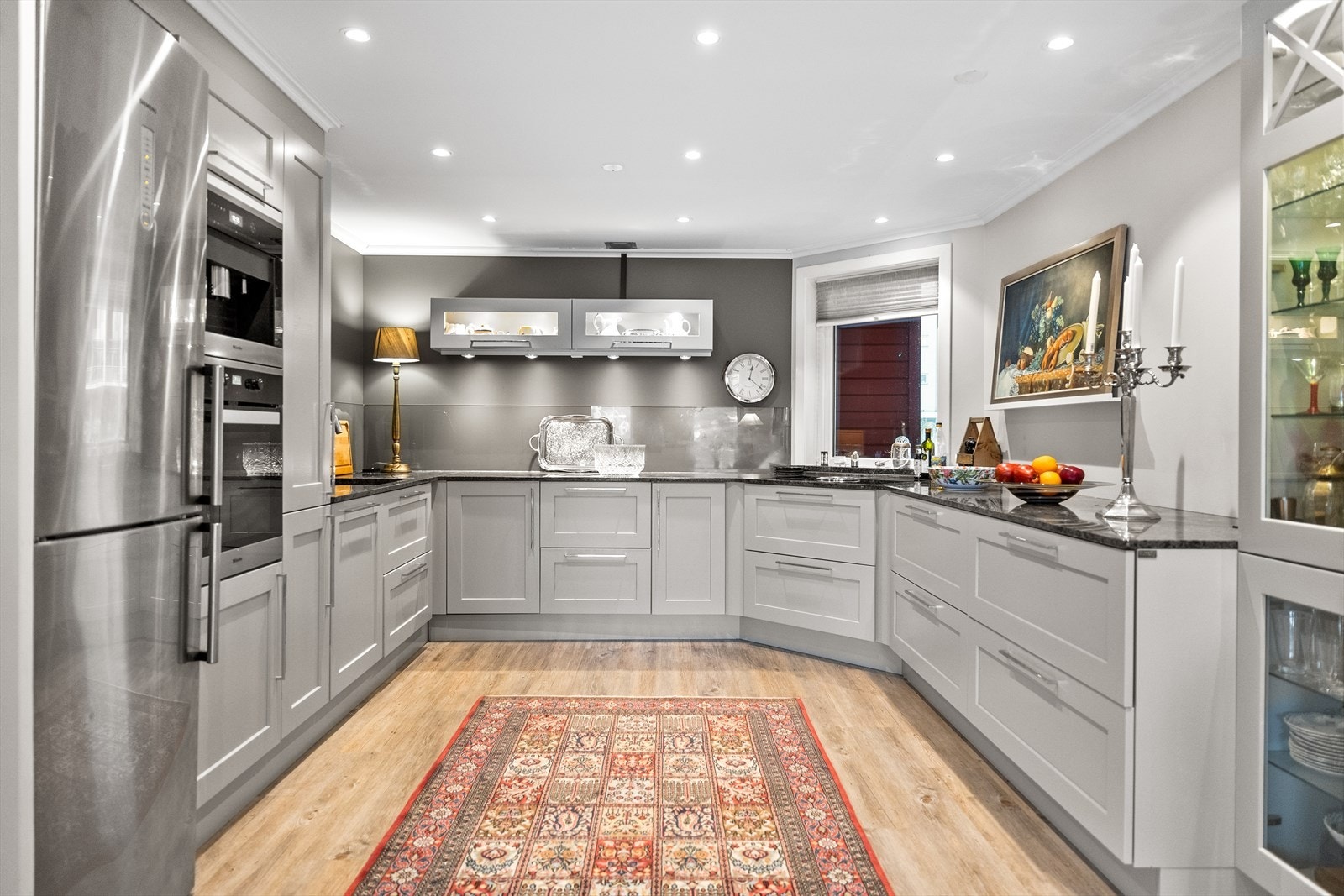 Kjøkkenet fremstår som både funksjonelt og eksklusivt - et stilrent rom der kvalitet og design går hånd i hånd. Den lekre innredningen fra Huseby har profilerte fronter som gir et klassisk, men moderne uttrykk. Galleribilde