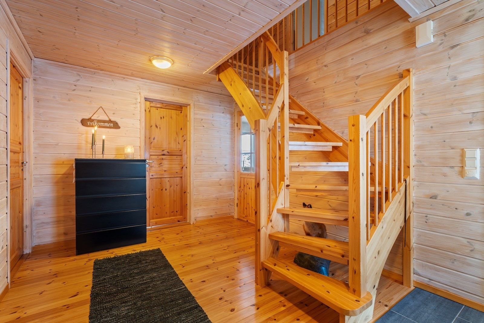 Romslig og innbydende gang med flislagt gulv og varmekabler i yttergangen. Her går det trapp til hems. Galleribilde