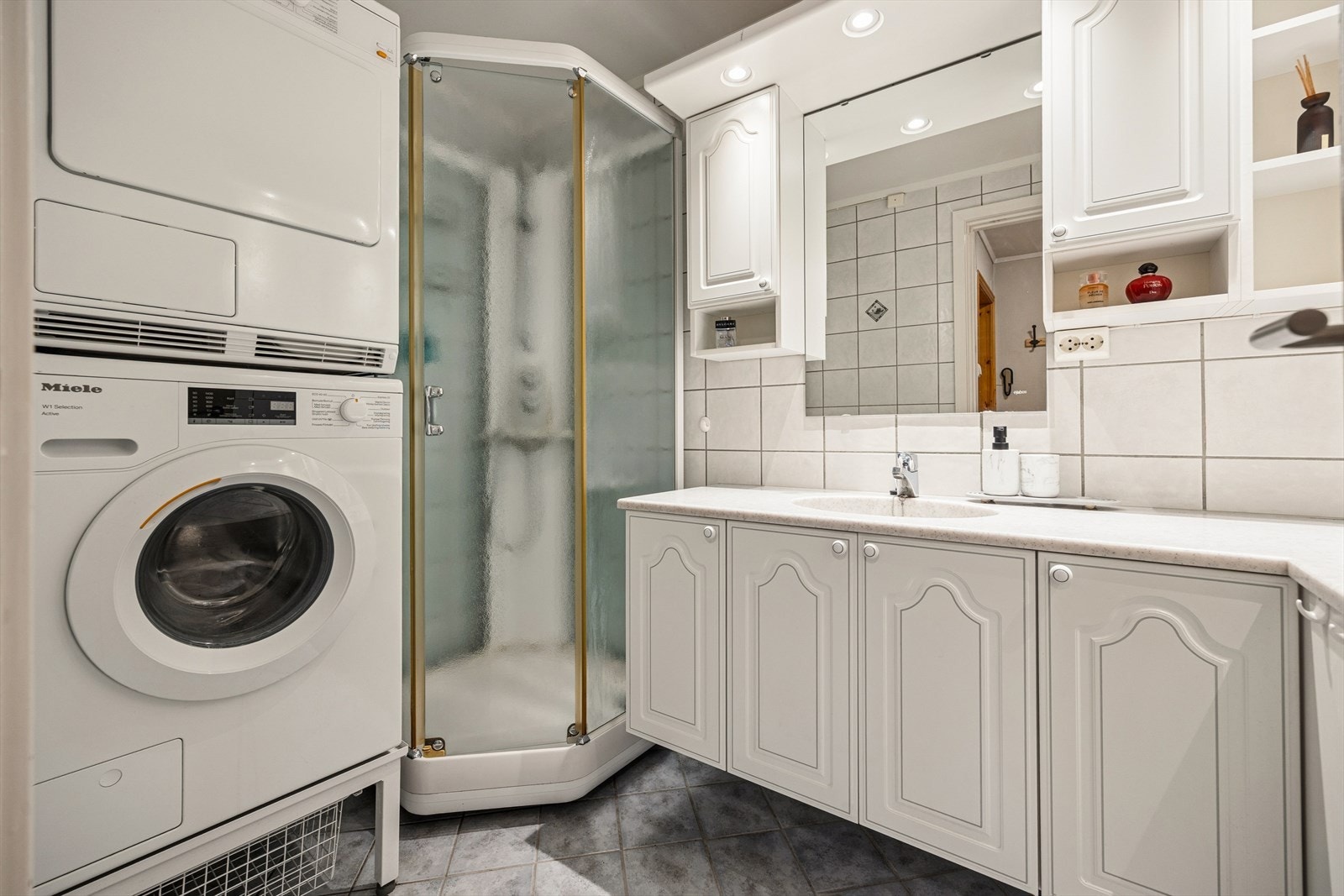 Baderommet er flislagt med varme i gulv. Praktisk dusjkabinett samt lys innredning og opplegg til vaskemaskin. Galleribilde