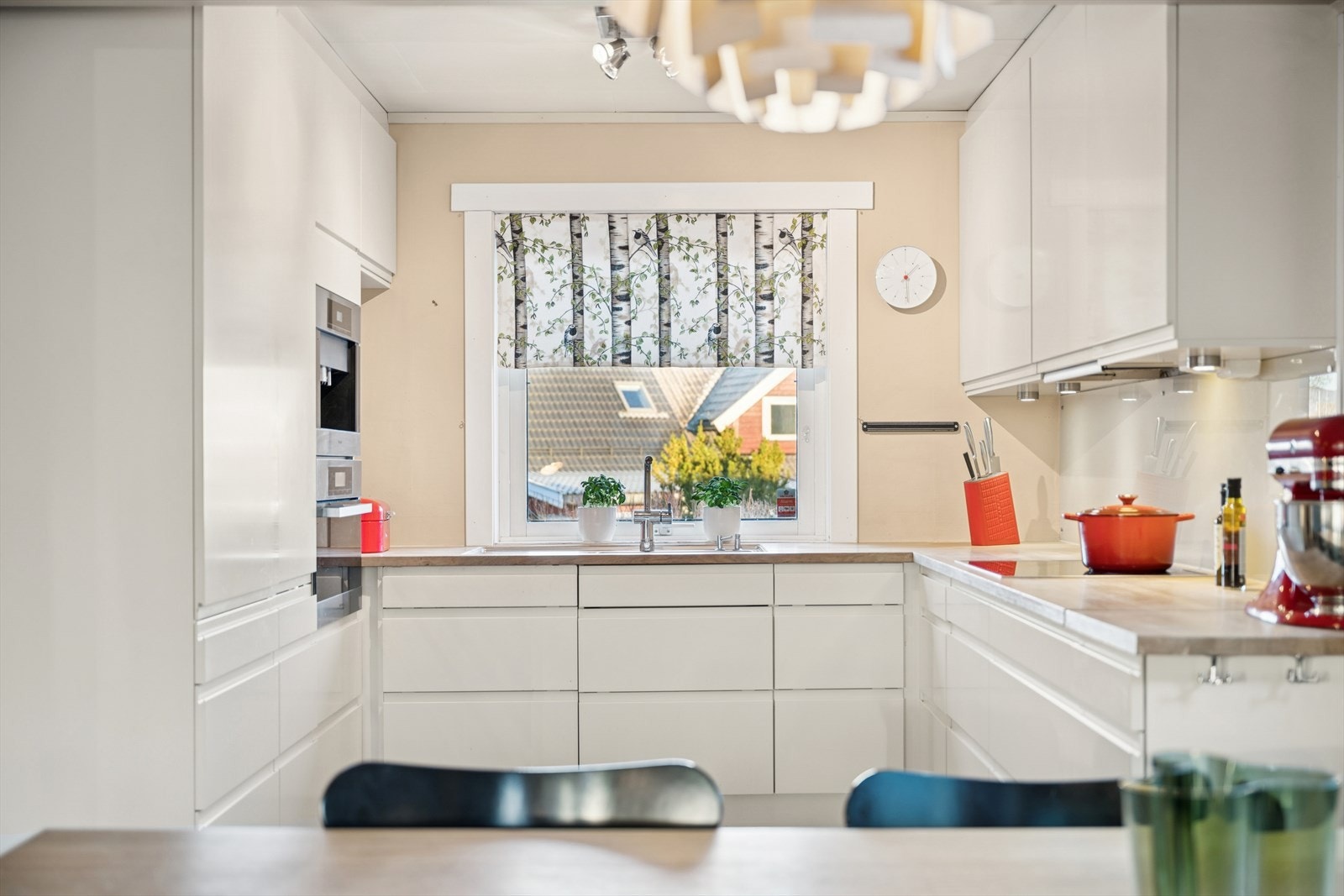 Det er belysning under overskapene og glassplater på deler av veggen over benken. Galleribilde