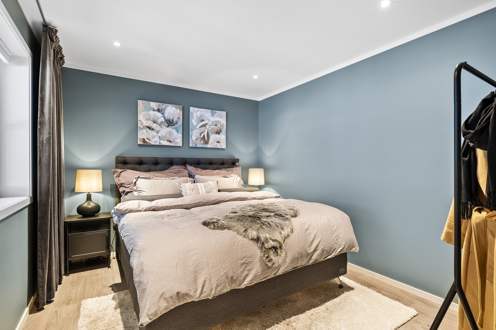 Soverommet har laminatgulv og slette, malte vegger i en lun blåfarge som skaper en rolig og behagelig atmosfære. Galleribilde