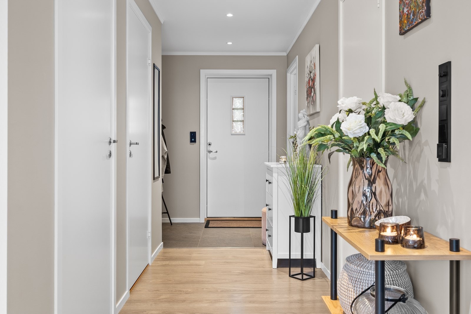 Entréen ønsker deg velkommen med skiferfliser og lune varmekabler, og leder deg videre inn til en åpen og romslig stue- og kjøkkenløsning. Laminatgulv og slette malte vegger gir et moderne preg i entréen. Galleribilde