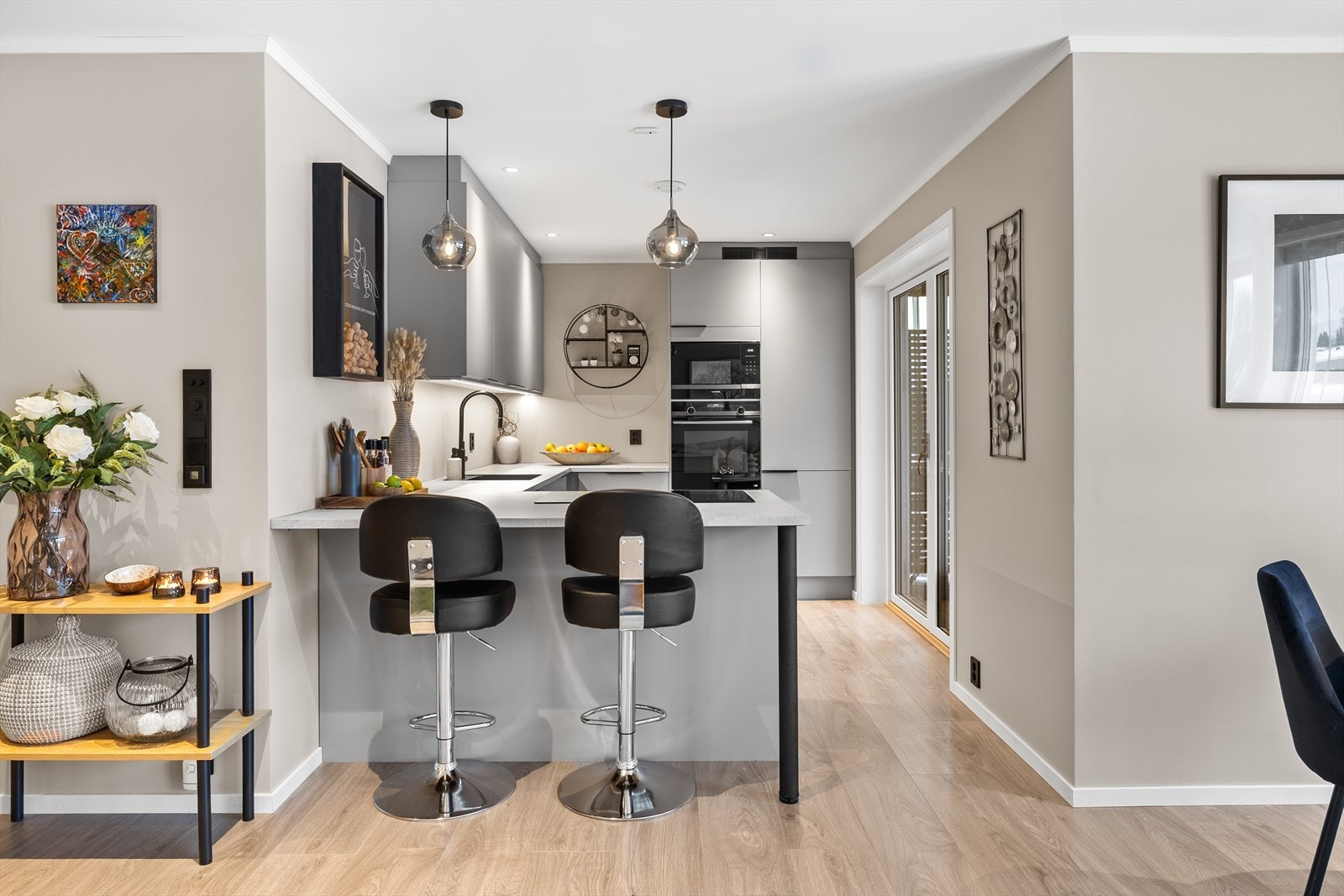 Den store halvøya fra Sigdal binder rommene sammen. Kjøkkenet har glatte fronter og benkeplate av laminat. Galleribilde