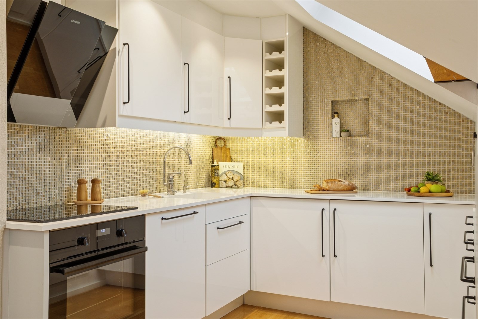 Kjøkkenet er utstyrt med et nedfelt stål vaskebeslag og en platetopp, som sammen med stekeovn og mikrobølgeovn gir gode muligheter for matlaging. Galleribilde