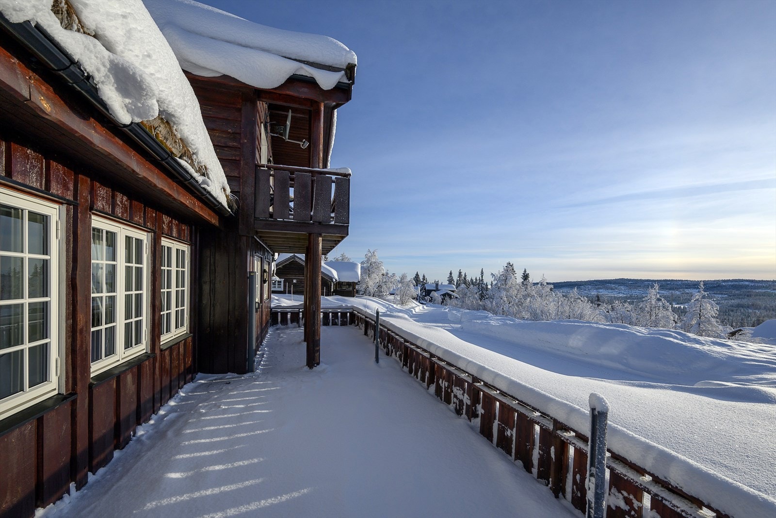 Hytta har både en romslig terrasse i første etasje og en overbygget balkong i andre. Galleribilde