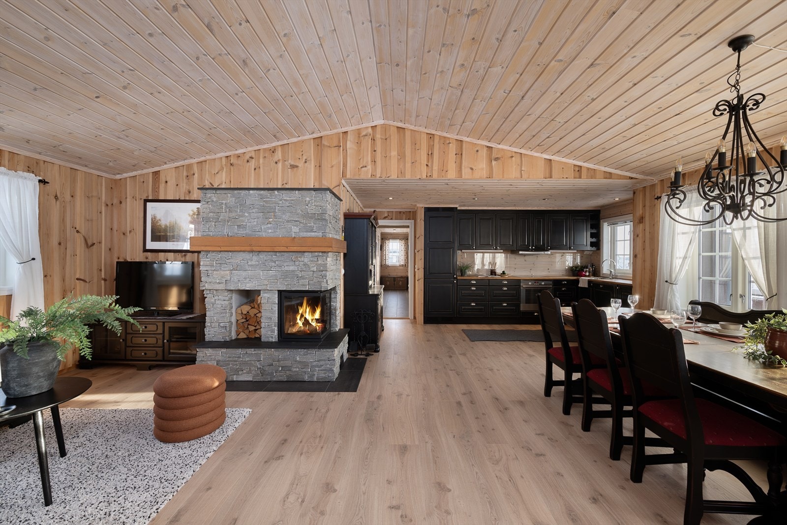 Den skiferforblendede peisen med innsats er sentralt plassert og skaper en lun atmosfære. Galleribilde