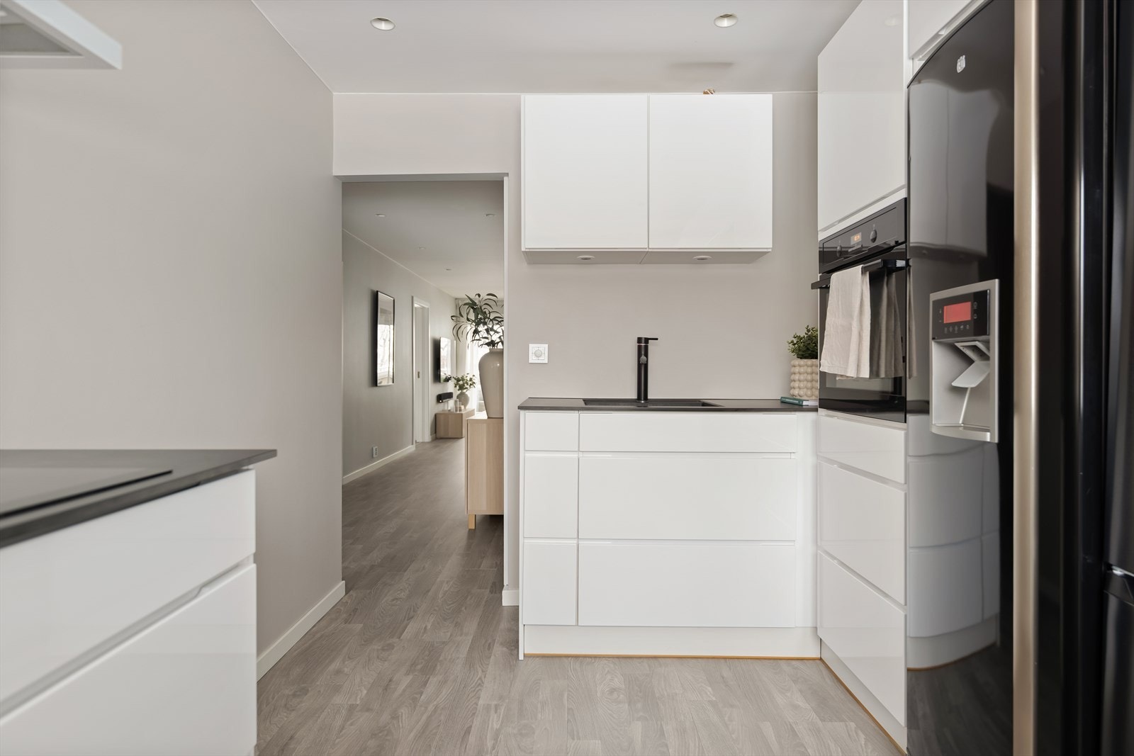 Fra kjøkkenet er det en åpen og sosial forbindelse til resten av leiligheten. Galleribilde