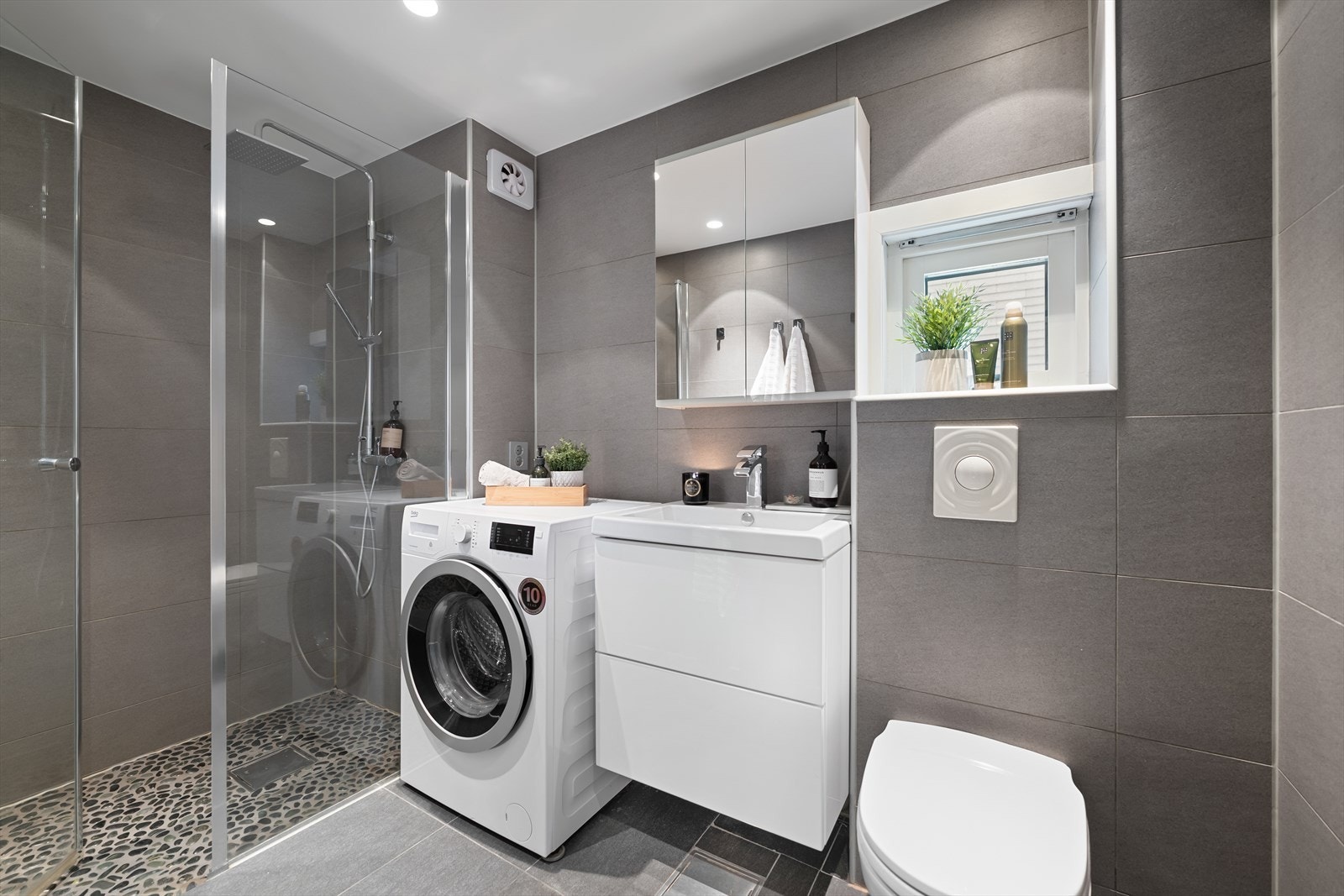 Leilighetens bad er romslig og delikat med downlights i himlingen og varme i gulvet. Galleribilde