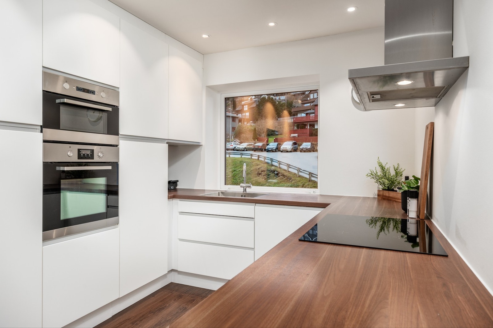 Pent kjøkken med integrert kjøleskap med fryser, oppvaskmaskin samt stekeovn og mikrobølgeovn plassert i komfortabel arbeidshøyde. Galleribilde