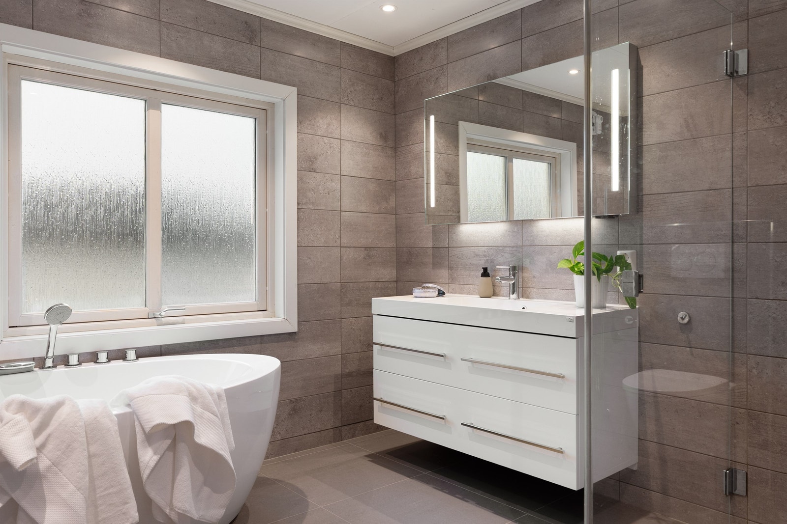 Gulv og vegger er helhetlig utført med fliser i grå nyanser. I gulvet er det naturligvis også elektrisk varme. Galleribilde