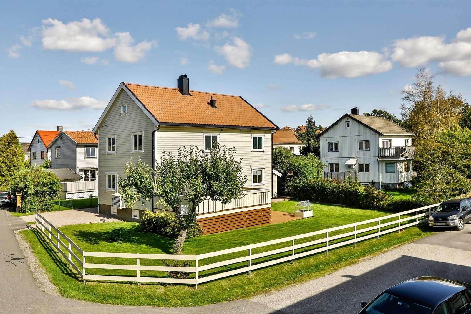 Hjørnetomten er på ca. 588 kvm., grensene er imidlertid usikre. Festeavgiften er kr. 2.026,- per år, neste regulering er i 2029. Bildet er tatt i 2019 og viser eiendommen sommerstid. Galleribilde