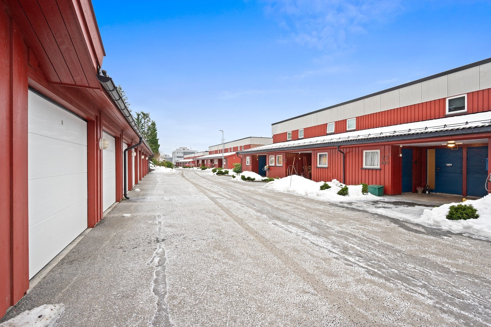 Parkeringsplass i rekkegarasje vis a vis inngang til leiligheten. Galleribilde