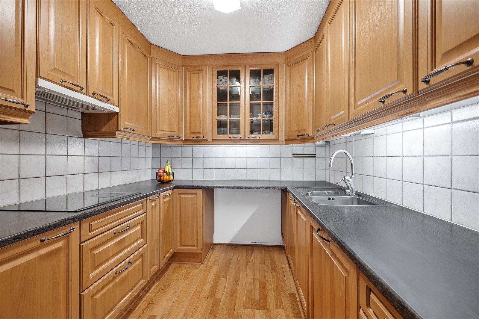 Pen kjøkkeninnredning med fronter av eik og integrerte hvitevarer Galleribilde