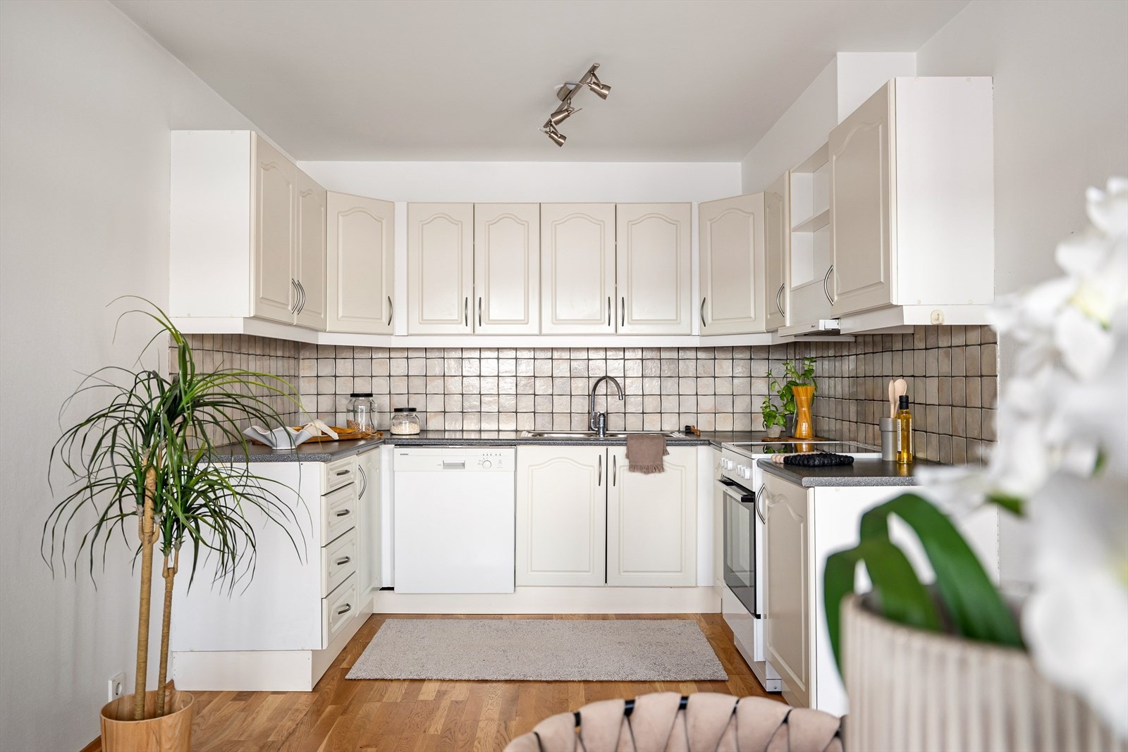 Kjøkken i hvit utførelse med god skapplass og praktisk benkeløsning. Galleribilde