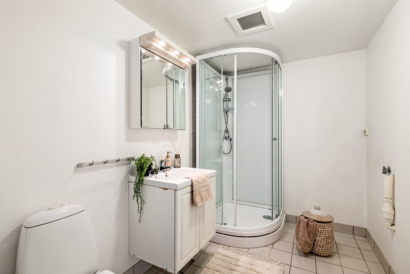 Badet er innredet med toalett, vask i seksjon og opplegg for vaskemaskin. Galleribilde