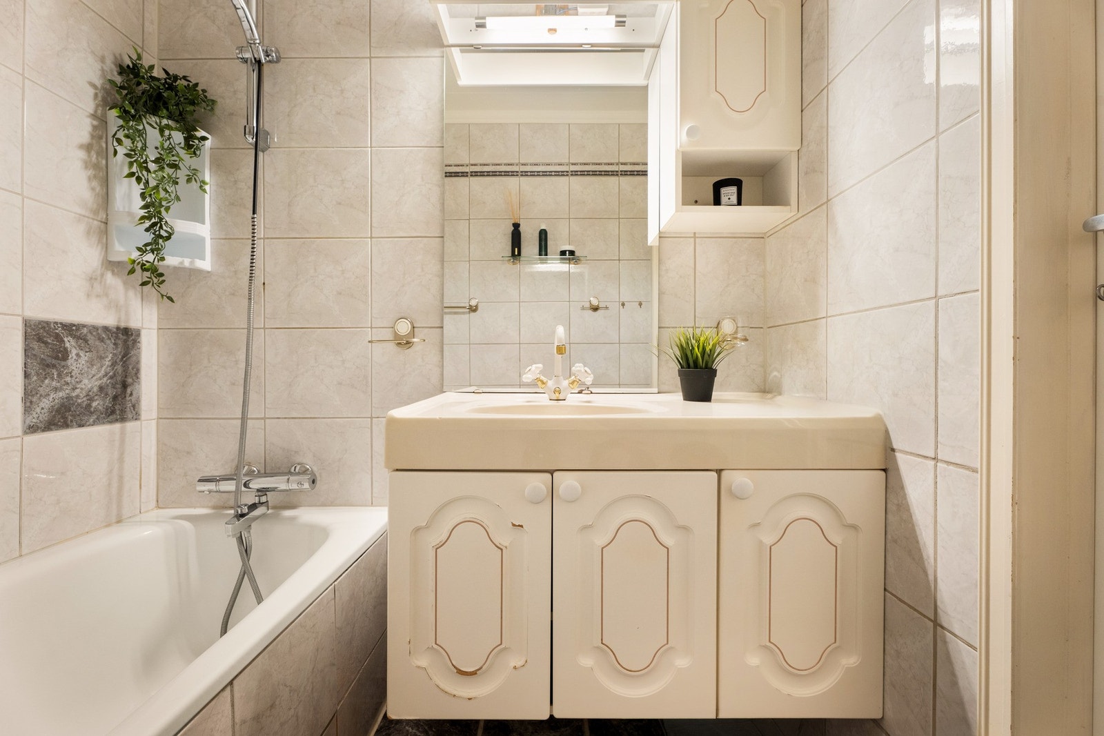 Badet har baderomsinnredning med servant og 2- greps blandebatteri, ett overskap og badekar. Galleribilde