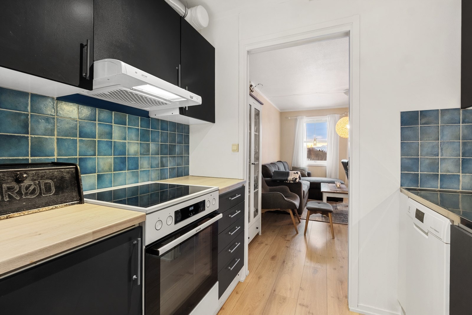 Kjøkkenet har en moderne innredning med glatte fronter og laminat benkeplate Galleribilde