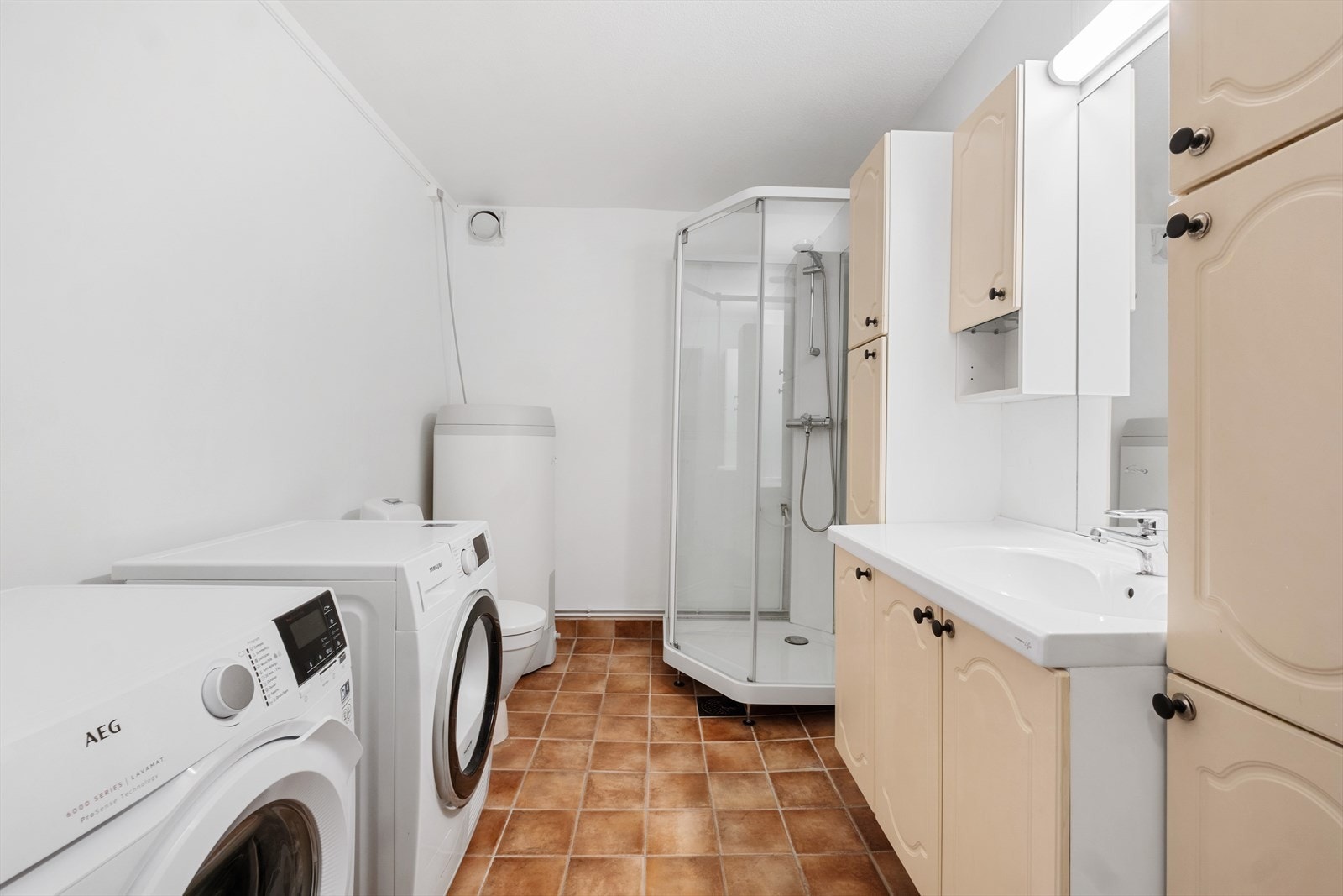 Badet er utstyrt med dusjkabinett, servant og toalett - veggmontert stråleovn gir behagelig varme Galleribilde