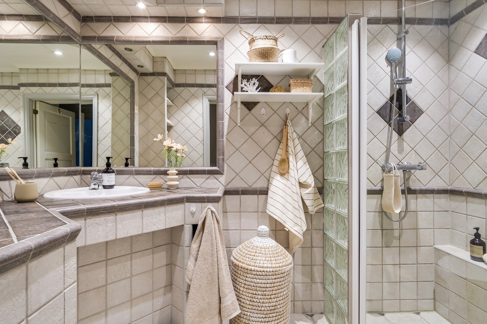 Leiligheten har et pent baderom med baderomsinnredning bestående av servant med speil, dusjhjørne og vegghengt toalett. Galleribilde