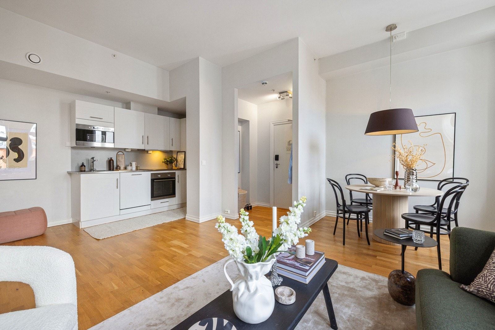 Kjøkkenet har hvite, profilerte fronter og en 28 mm tykk, grålaminert benkeplate. Galleribilde