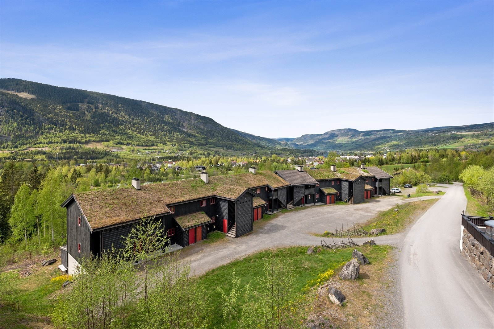 Parkering på østsiden av bygget. Leiligheten har inngang på bakkeplan, på nedsiden av bygget. Galleribilde