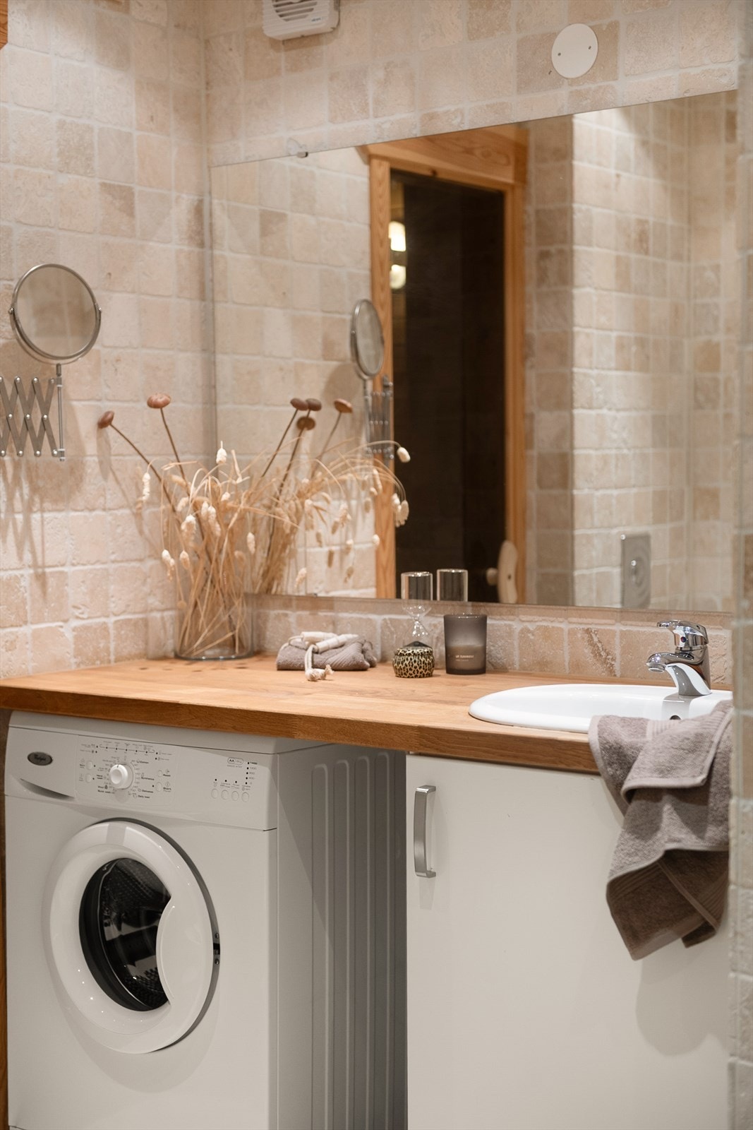 Innredning med nedfelt servant i heltre benkeplate og speil på vegg. Elektrisk styrt vifte. Galleribilde