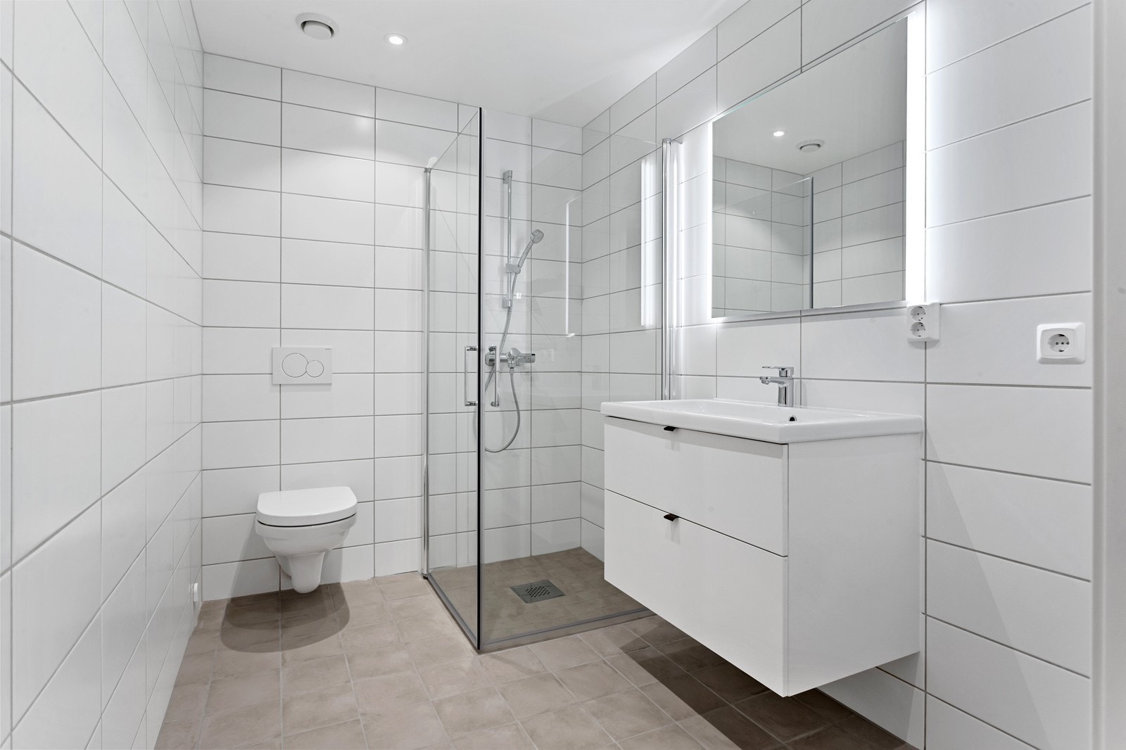 Delikat og helfliset bad med varmekabler i gulv og opplegg for vaskemaskin. Galleribilde