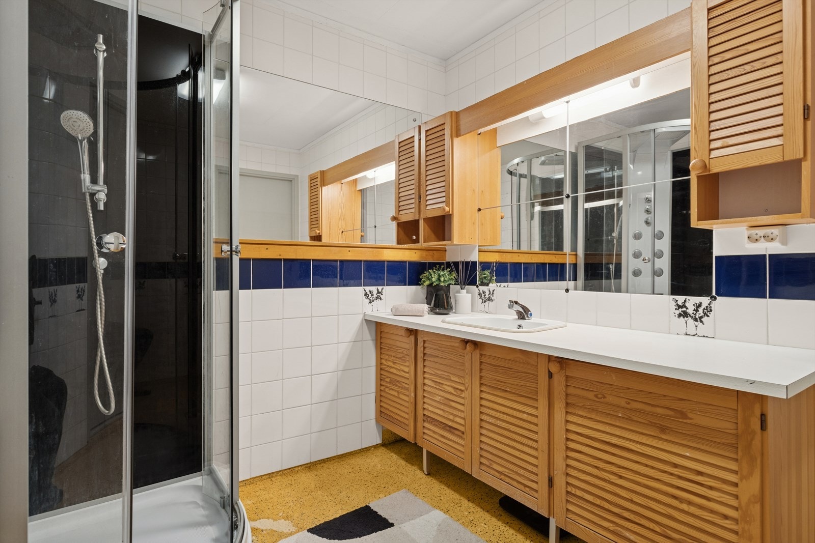 Baderom utstyrt med dusjkabinett og innredning med servant. Galleribilde