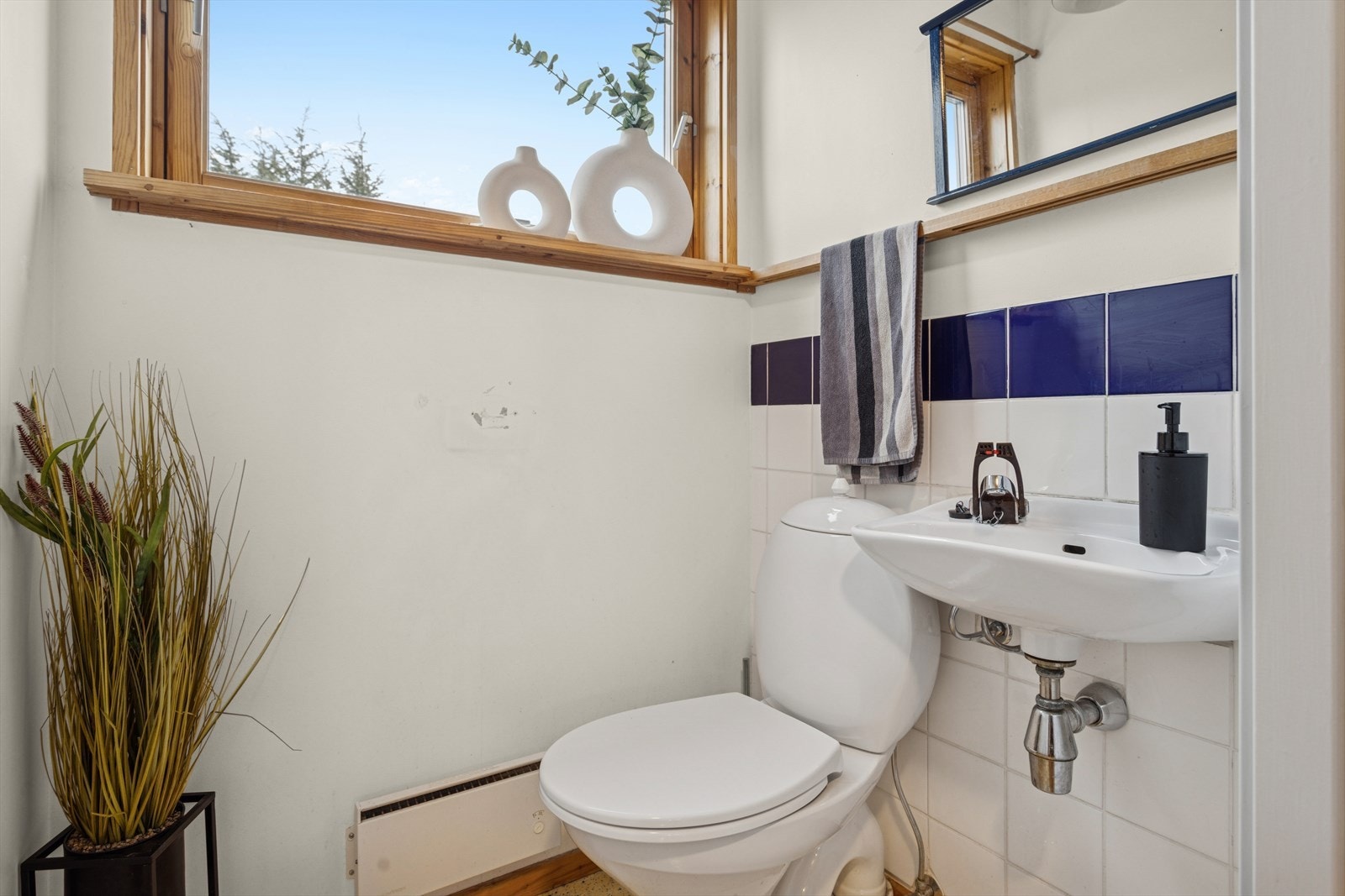 Toalettrom med vegghengt servant og et gulvmontert toalett. Galleribilde