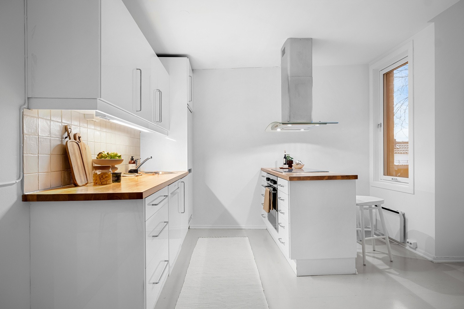 Innredningen har hvite glatte fronter og benkeplate av tre med nedfelt oppvaskkum. Galleribilde