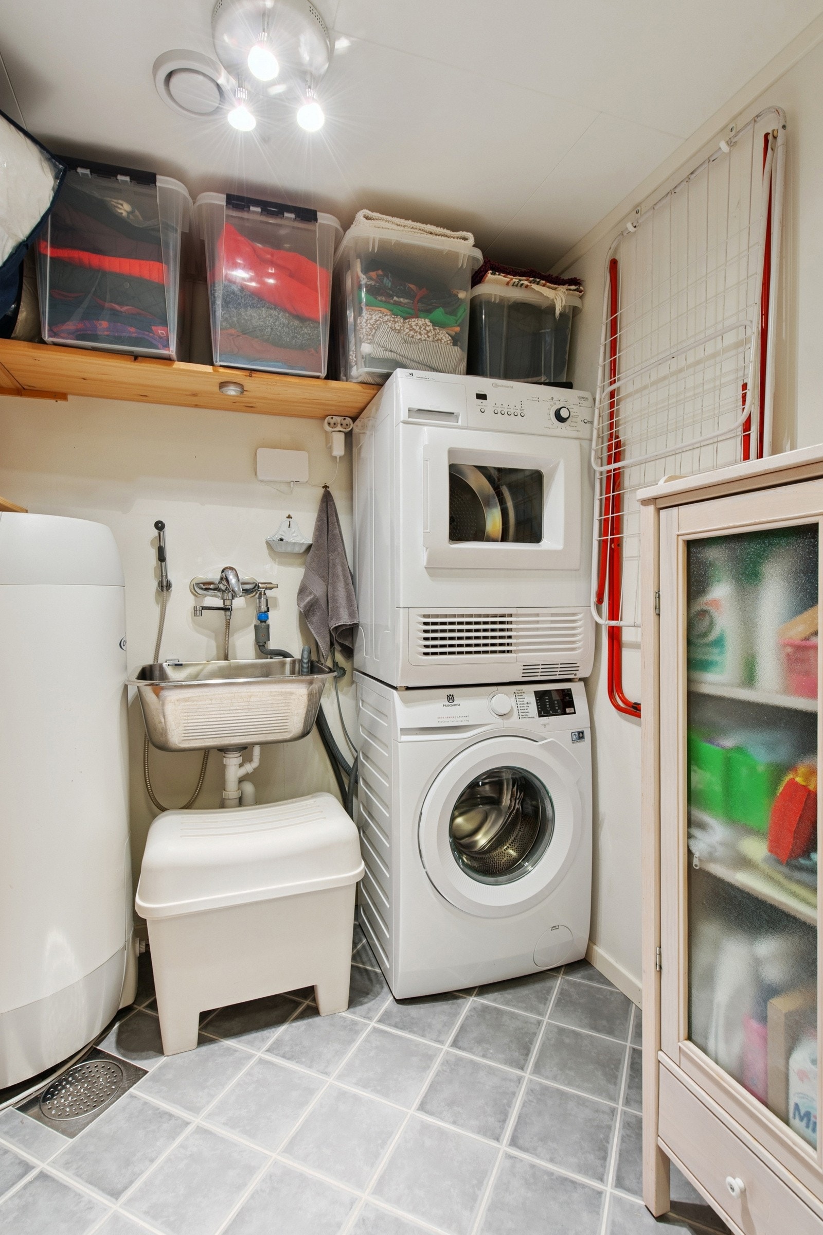 Vaskerom med flislagt gulv med sluk, utslagsvask og opplegg for vaskemaskin. Galleribilde