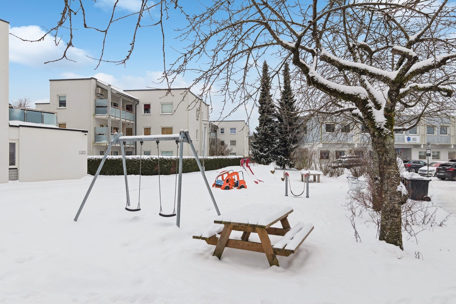 Uteområde med sitteplass og lekeapparater, et perfekt sted for både avslapning og lek i trygge omgivelser. Galleribilde