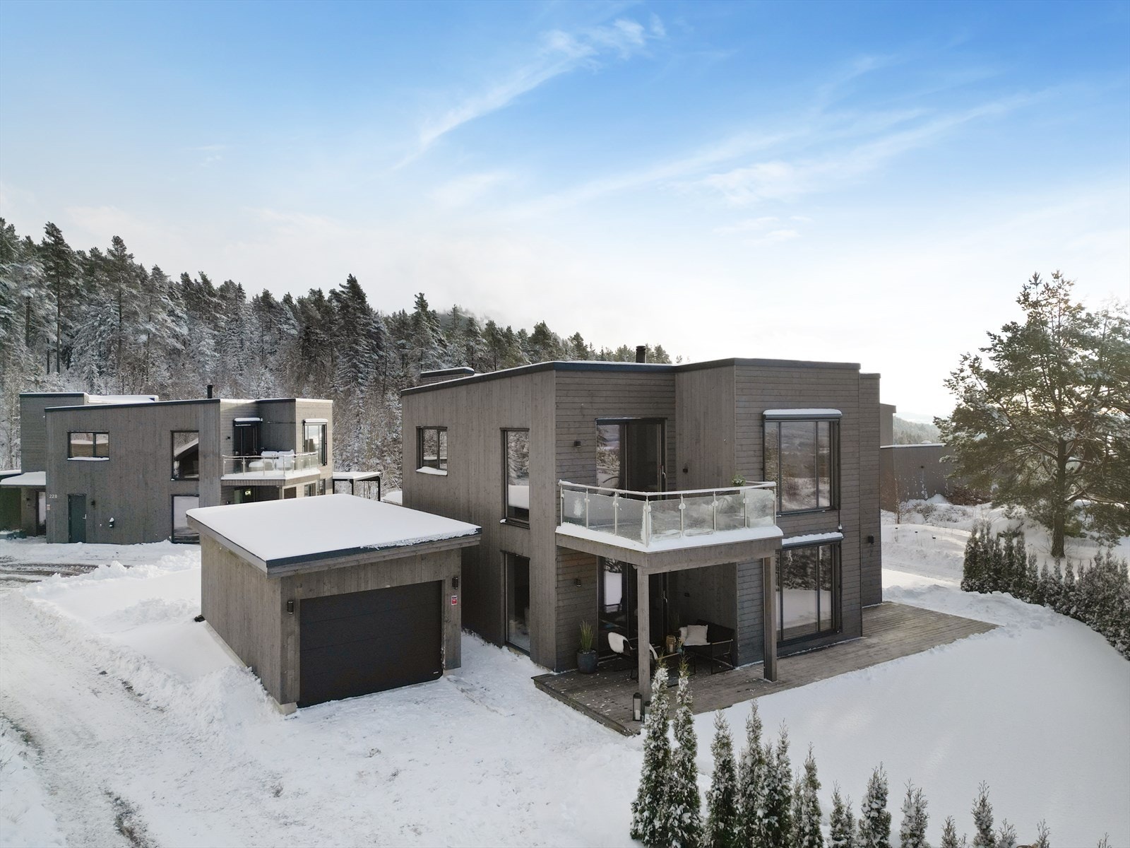 Innkjørsel og gangsti frem til overbygget inngangsparti er gruslagt. På tomten er det for øvrig oppført en enkel garasje med én biloppstillingsplass. Mulighet til parkering også foran denne, i innkjørsel. Galleribilde