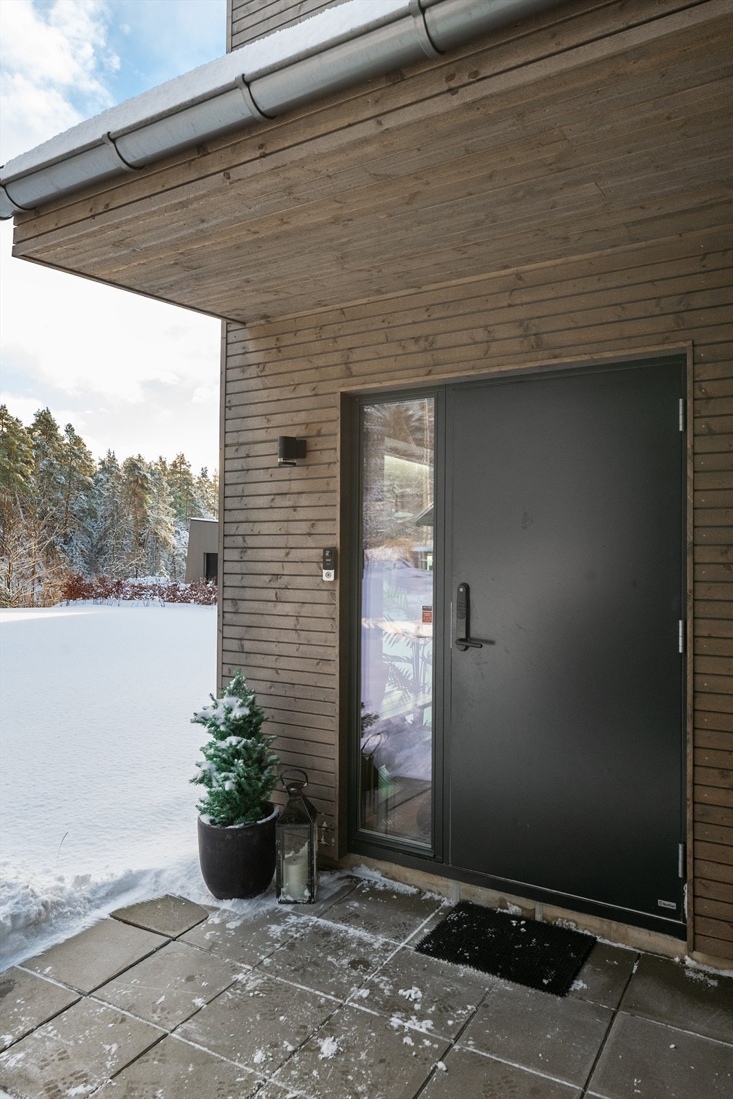 Velkommen! Hyggelig overbygget inngangsparti med fin sortmalt dør som ønsker deg velkommen hjem. Galleribilde