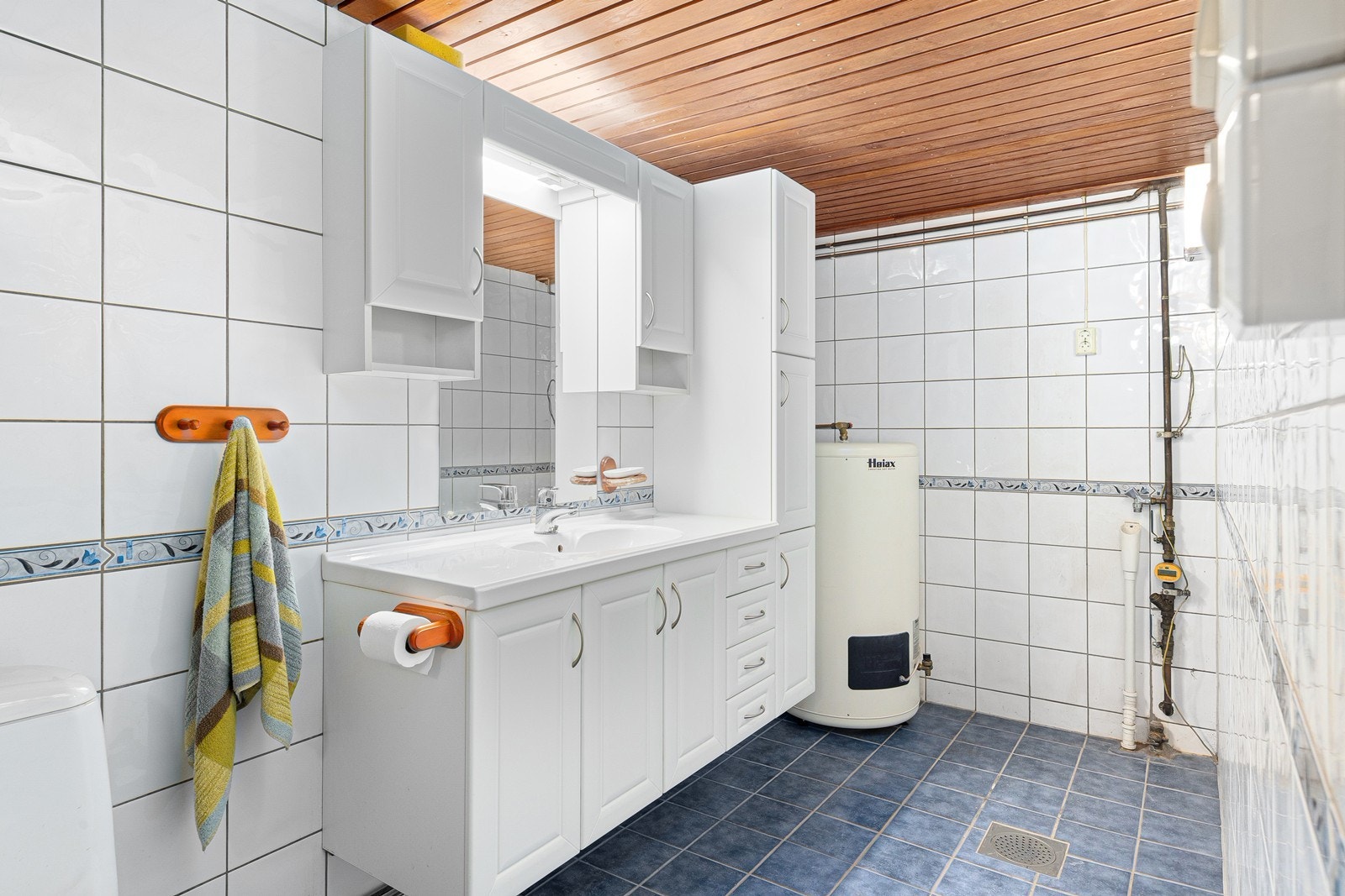 Badet inneholder servantinnredning, dusjhjørne, toalett og opplegg for vaskemaskin. Galleribilde