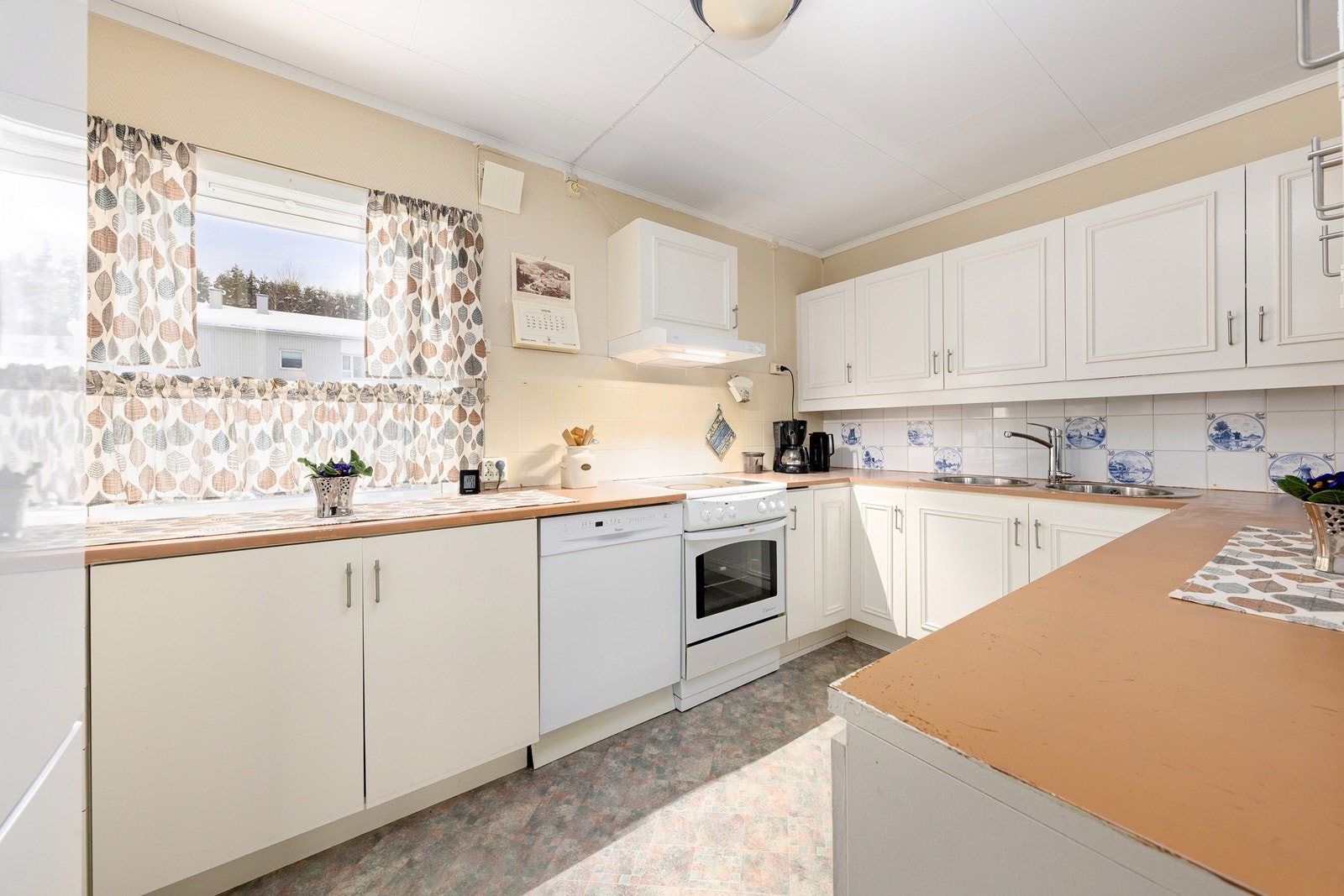 Kjøkkeninnredning med god skap- og benkeplass. Frittstående hvitevarer. Galleribilde