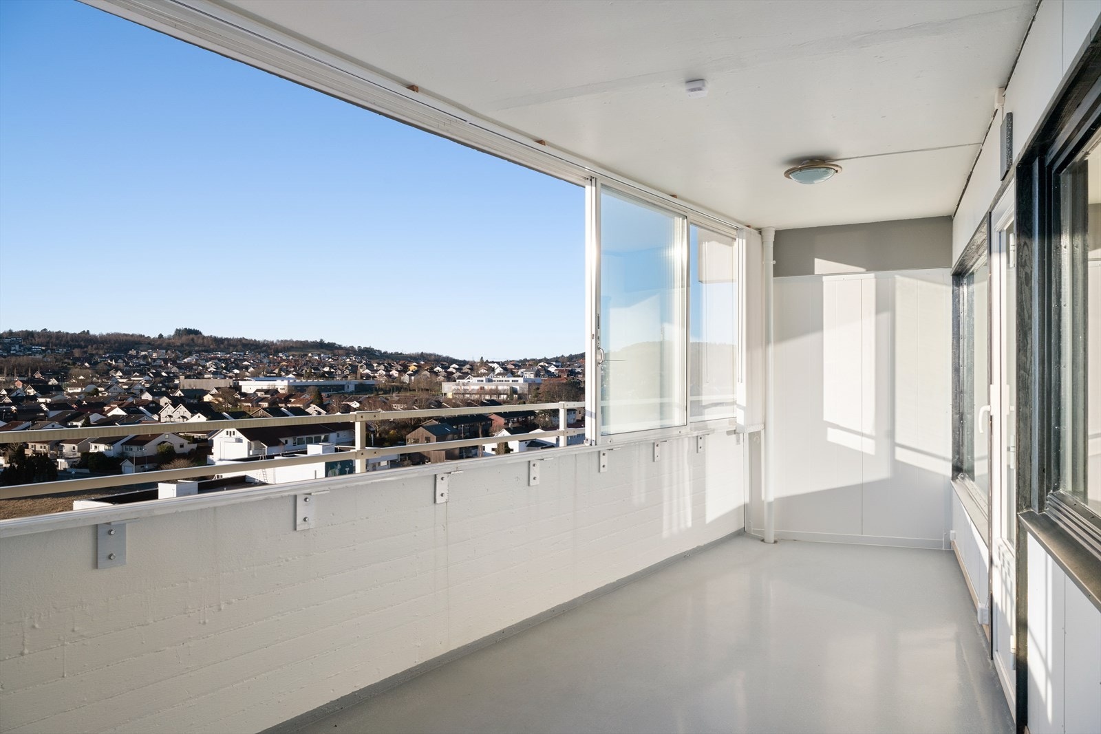 Fra stuen er det direkte utgang til en romslig innglasset balkong med skyvevinduer og god plass til møblering - et ekstra bruksrom store deler av året. Galleribilde