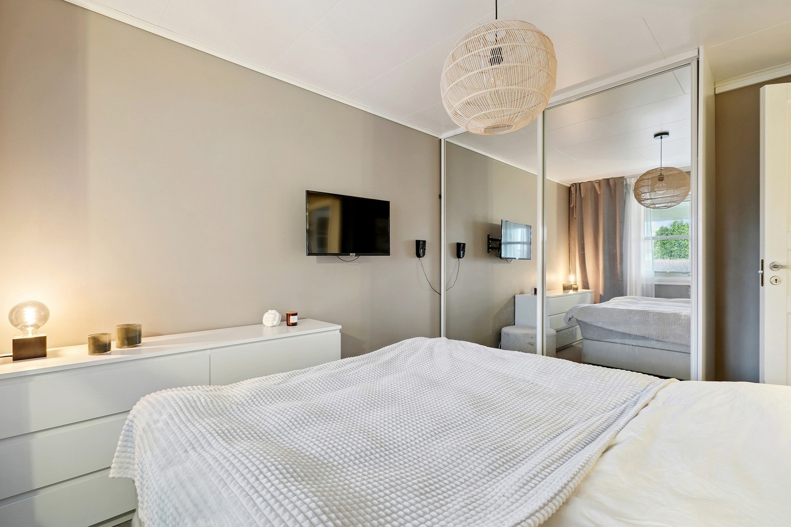 Innredet med nattbord, dobbeltseng og garderobeskap med skyvedører. Galleribilde